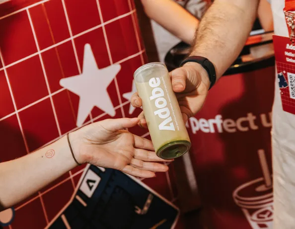Branded Adobe drink handed to a guest